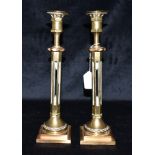 A PAIR OF HEAVY BRASS CANDLESTICKS with removable sconces, pierced octagonal stems and stepped