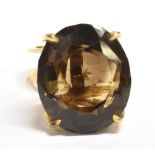 SMOKY QUARTZ ABSTRACT RING The faceted oval stone measuring 2.1 x 1.8cm on an abstract open work