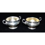 A PAIR OF SILVER CONDIMENT POTS Both stand approx 3.0cm high on short pedestals with C scroll