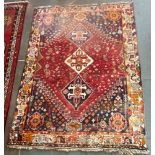 A RED GROUND WOOL RUG triple pole central medallion, 220cm x 165cm Condition Report : generally