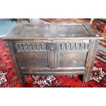 A SMALL PANELLED OAK COFFER the front with carved decoration, 87cm wide 46cm deep 57cm high