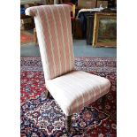 A PRIE-DIEU CHAIR In striped upholstery, the turned frontal supports with brass casters