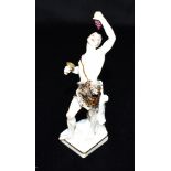 A 19TH CENTURY PORCELAIN FIGURE OF BACCHUS standing wearing a leopard pelt, a bunch of grapes in one