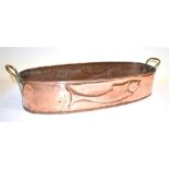 AN OVAL COPPER FISH KETTLE with brass handles, embossed with fish to side, 61cm wide excluding