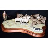 A BORDER FINE ARTS GROUP Of a shepherd and his collie dog driving sheep into a pen, length 42cm,