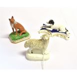 A STAFFORDSHIRE FIGURE OF A SEATED FOX and two further similar figures of a recumbent hound and a