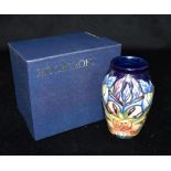 A LIMITED EDITION MOORCROFT POTTERY VASE decorated in the 'Geneva' pattern on a blue ground,