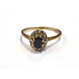 MODERN SAPPHIRE & DIAMOND CLUSTER RING A 10.5 x 8.0mm claw and grain set oval cluster, featuring a 6