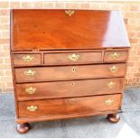 A GEORGE III MAHOGANY BUREAU the interior fitted with central cupboard flanked by pigeonholes,