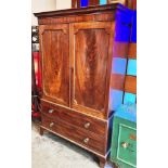 A FIGURED MAHOGANY LINEN PRESS with dentil frieze, pair of panelled doors opening to hanging