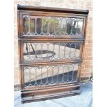 AN OAK THREE TIER GLOBE WERNICKE SECTIONAL BOOKCASE with lead glazed up and over doors and drawer to