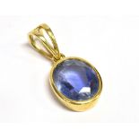CEYLONESE SAPPHIRE IN 18CT GOLD PENDANT A 2.5cm long, 18ct yellow gold oval bezel set pendant with