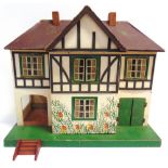 A TRI-ANG DOLL'S HOUSE the mock-Tudor, gabled, side-hinged front elevation opening to reveal an