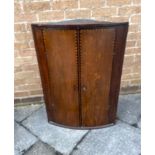 AN OAK HANGING BOW FRONT CORNER CABINET with barbers pole parquetry decoration, 66cm wide 95cm
