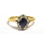SAPPHIRE & DIAMOND OVAL CLUSTER RING Oval mixed cut very dark blue sapphire, estimated 0.65