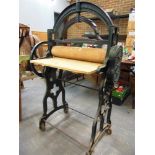 AN 'ORIGINAL HALLER' CAST IRON MANGLE with a wood top and rollers, the frame painted dark green,