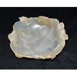A CHINESE JADE BRUSH WASHER naturalistically carved as a lotus leaf supported by floral stems and