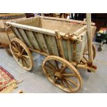 A WOODEN DOG CART with lift-out front and rear end panels, the spoked wheels with metal band