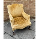 AN EDWARDIAN UPHOLSTERED ARMCHAIR with camel back, stuffover seat with shaped apron, on cabriole