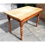 A RECTANGULAR PINE KITCHEN TABLE raised on four turned supports, the top 122cm x 72cm, 79cm high;