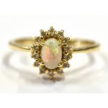 14CT OPAL & DIAMOND HALO RING Central white opal, oval cabochon with very good play of colour,