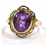 9CT GOLD & AMETHYST RING Bezel set oval mixed cut amethyst, estimated 2.6 carats, within rope work