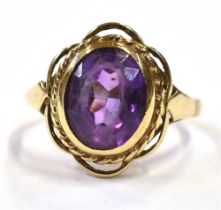 9CT GOLD & AMETHYST RING Bezel set oval mixed cut amethyst, estimated 2.6 carats, within rope work