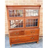 AN EARLY 20TH CENTURY MAHOGANY BOOKCASE with two pairs of leaded glazed doors over above an