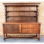 A LARGE OAK DRESSER the upper section with two shelves, the base with a cupboard and a pair of