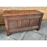AN OAK RECTANGULAR COFFER with candle box, carved triple panel front and on stile feet, height 65cm,
