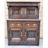 AN OAK COURT CUPBOARD WITH CARVED AND MOULDED DECORATION 115cm wide 160cm high 53cm deep Condition