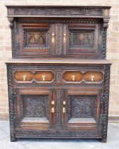 AN OAK COURT CUPBOARD WITH CARVED AND MOULDED DECORATION 115cm wide 160cm high 53cm deep Condition