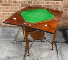 AN EDWARDIAN MAHOGANY ENVELOPE CARD TABLE the baize lined interior with dished counter wells, with