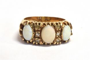 WHITE OPAL CABOCHON 9CT GOLD RING Three oval white opal cabochons alternating with single cut