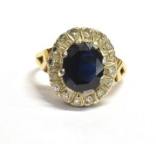 SAPPHIRE & DIAMOND HALO RING Dark blue oval mixed cut sapphire approx 10.7 x 7.0mm, surrounded by