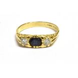 SAPPHIRE & DIAMOND THREE STONE RING Set in 18ct yellow gold, a round mixed cut dark blue sapphire,