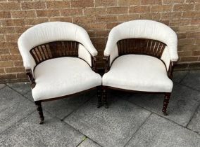 A PAIR OF EDWARDIAN HOOP BACK TUB CHAIRS with railed back rests and turned frontal supports, with