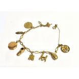9CT GOLD CHARM BRACELET 22cm long with mostly 9ct gold charms attached, octagonal monogrammed locket