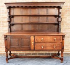 A LARGE OAK DRESSER the upper section with two shelves, base with cupboard and pair of drawers,