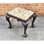 A CARVED MAHOGANY STOOL with needlework upholstered drop-in seat, on cabriole supports with claw and