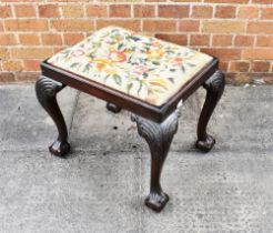 A CARVED MAHOGANY STOOL with needlework upholstered drop-in seat, on cabriole supports with claw and