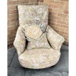 AN UPHOLSTERED ARMCHAIR on turned supports and casters, with loose cushion to match, height 77cm,