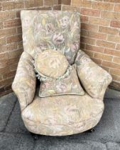 AN UPHOLSTERED ARMCHAIR on turned supports and casters, with loose cushion to match, height 77cm,