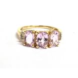PINK TOPAZ & DIAMOND 9CT GOLD RING Three oval mixed cut pale pink topaz, approx 6.8 x 4.8mm, flanked