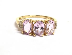 PINK TOPAZ & DIAMOND 9CT GOLD RING Three oval mixed cut pale pink topaz, approx 6.8 x 4.8mm, flanked