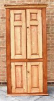 A VICTORIAN PINE TALL CUPBOARD with four panelled doors enclosing three shelves, with dentil