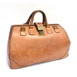 A TAN LEATHER POLO/HUNTING BAG with twin carrying handles and a pair of fastening straps and with
