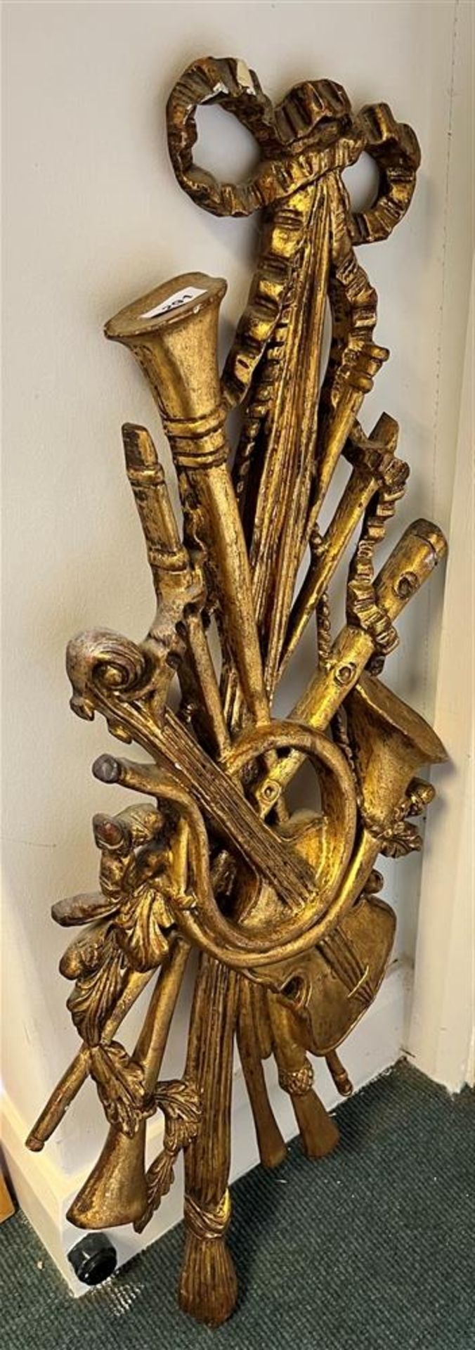 A WALL HANGING IN GILT OF MUSICAL INSTRUMENTS