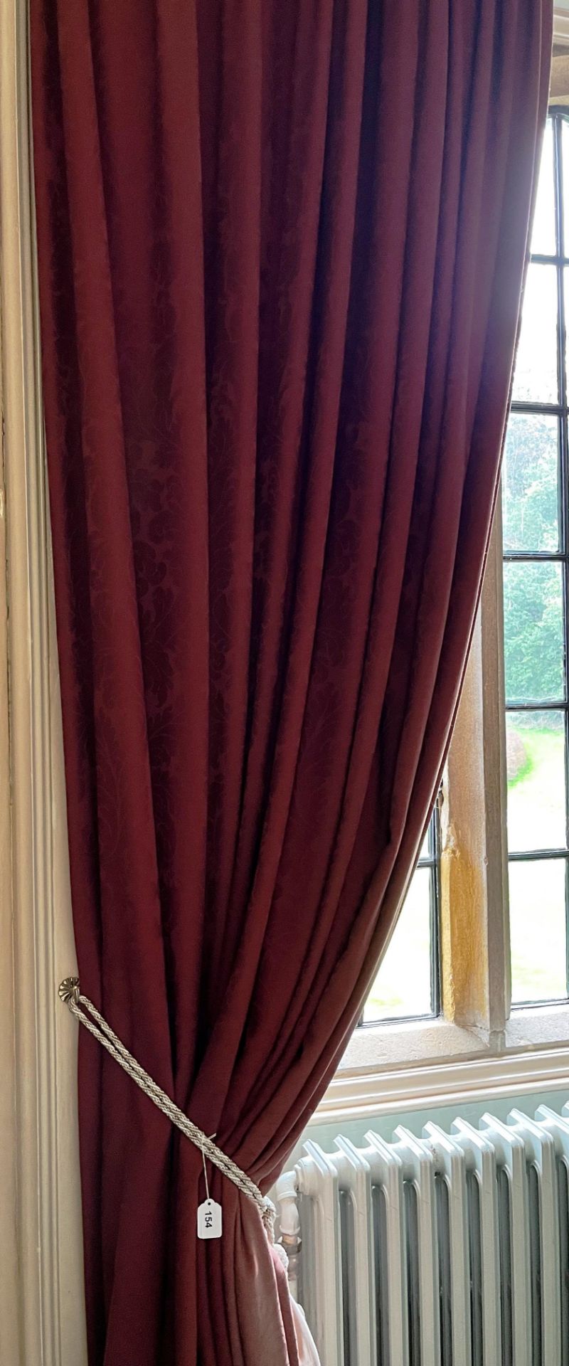 A PAIR OF RED LINED CURTAINS