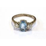 18CT AQUAMARINE & DIAMOND RING Central oval mixed cut aquamarine, estimated 1.1 carats, flanked by